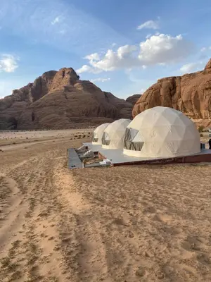 two tents in the desert with mountains in the background at Camp safaa rum in Wadi Rum