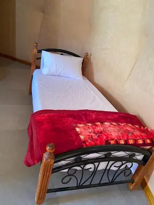 a bedroom with a bed with a red blanket at Camp safaa rum in Wadi Rum