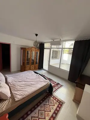 a bedroom with a bed and a large window at Lemon garden apartment in Aqaba