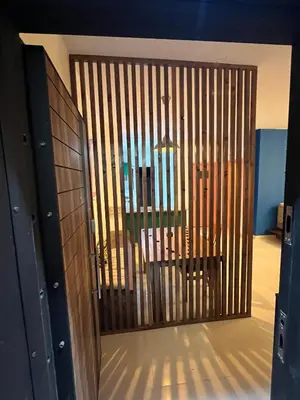a large wooden door in a room with a table at Lemon garden apartment in Aqaba