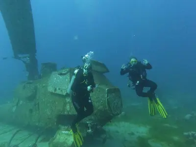 two people are diving in the water in the ocean at Lemon garden apartment in Aqaba