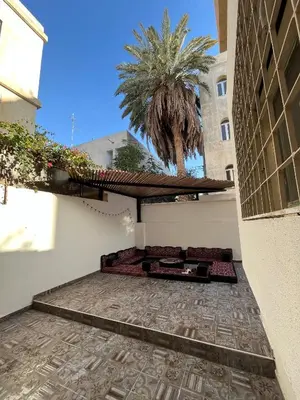 a view from the outside of a building with a palm tree at Lemon garden apartment in Aqaba