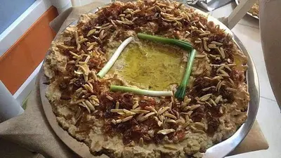 a pie with nuts on top of it in a box at look house in Amman