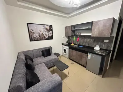 a living room with a couch and a kitchen at Luxury Hotel apartment in Amman