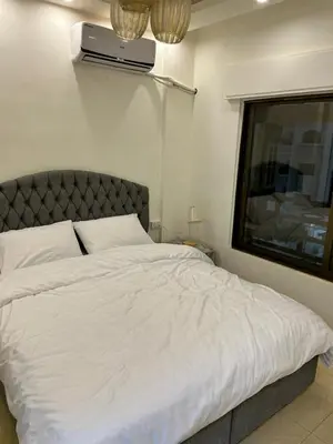 a bedroom with a white bed and a window at Luxury Hotel apartment in Amman
