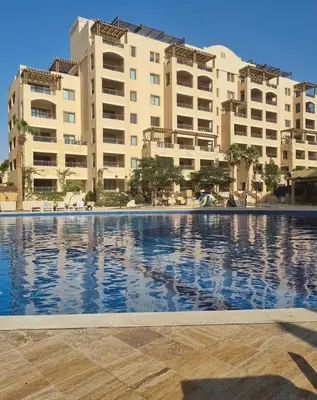 a large swimming pool in front of some buildings at Samarah Resort D32 in Sowayma
