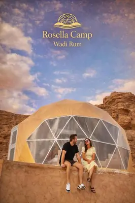 a man and a woman sitting in a tent at Rosella Camp Wadi Rum in Wadi Rum
