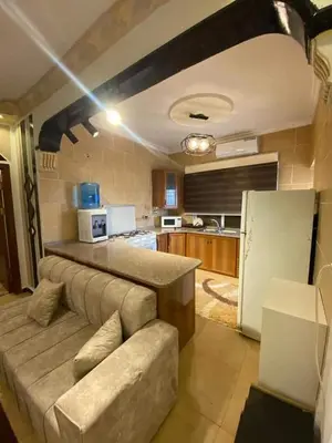 a living room with a couch in a kitchen at Nerman home in ‘Awjān ash Shamālī