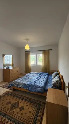 a bedroom with a bed and a large window at Blackbird Sanctuary homestay & Art Cafe in Ajloun