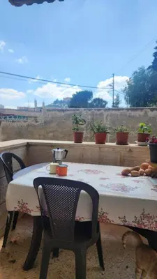 a table and chairs on a balcony with a view at Blackbird Sanctuary homestay & Art Cafe in Ajloun