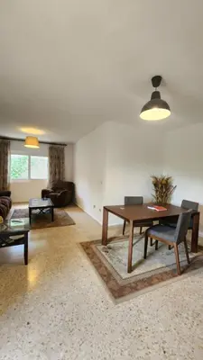 a living room with a table and a couch at Blackbird Sanctuary homestay & Art Cafe in Ajloun