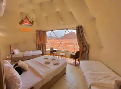 a bedroom with two beds and a large window at Daria Luxury Camp in Wadi Rum