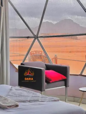 a room with a window and a bed with a red pillow at Daria Luxury Camp in Wadi Rum