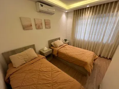 two beds in a small room with a window at Casa De Centre 1 in Amman