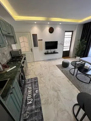 a kitchen with a stove and a living room at Casa De Centre 1 in Amman
