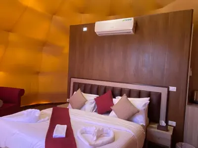 a bedroom with a large bed with a white bedspread at Wadi Rum, sands of Mars in Wadi Rum