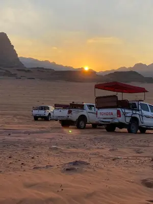 two trucks parked in the desert at sunset at Wadi Rum, sands of Mars in Wadi Rum