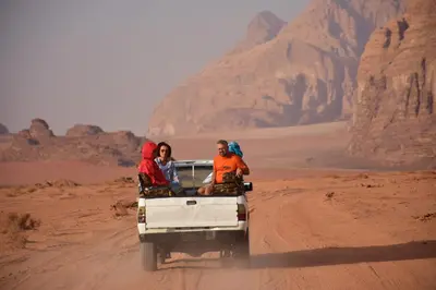 three people in the back of a truck in the desert at Wadi Rum, sands of Mars in Wadi Rum