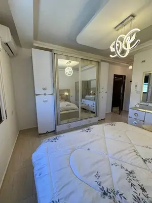 a large bedroom with a large bed and a chandelier at 3 bed rooms apartment - 3 غرف نوم مفروشة دوار المشاغل عمان in Amman