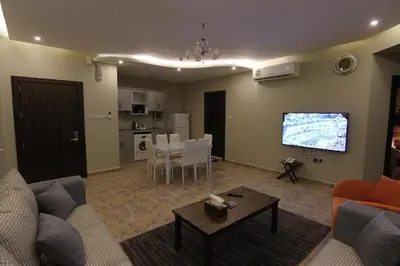 a living room with a couch and a tv and a table at GOJORDAN INN in Irbid