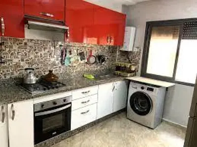 a kitchen with red cabinets and a washing machine at 89 inn in Amman