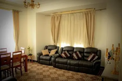 a living room with a black leather couch at 89 inn in Amman