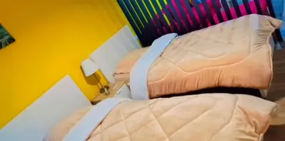 a bedroom with a bed and a yellow wall at Lovely Studio appartment in a central location in Amman