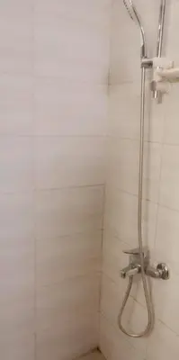 a shower with a shower head in a bathroom at Lovely Studio appartment in a central location in Amman
