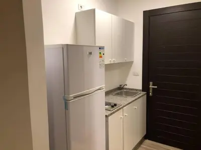 a kitchen with a refrigerator and a sink at Lovely Studio appartment in a central location in Amman