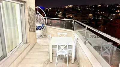 a balcony with a table and chairs on a building at شقة مفروشة اربع غرف نوم عبدون in Amman