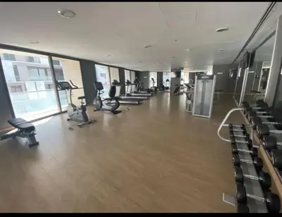 a gym with treadmills and chairs in a building at Amman Damac one bedroom boulevard Abdali استديو في داماك عمان الاردن in Amman