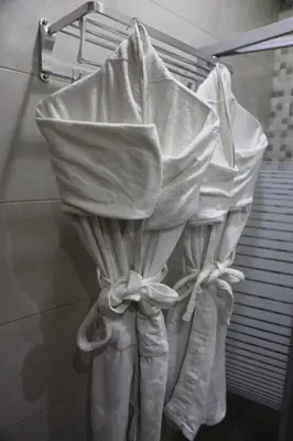 a bunch of white shower curtains in a bathroom at Hotel Rayshan in Amman