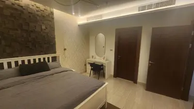 a bedroom with a bed and a desk and a mirror at Amazing new apartment in the middle of Amman in Amman