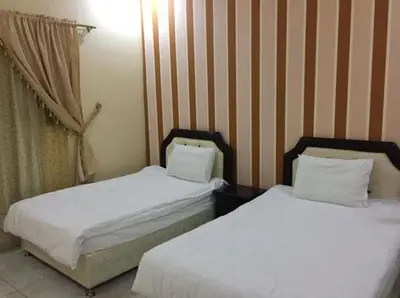 two beds sitting next to each other in a bedroom at Jordan House INN in Amman
