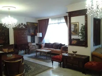a living room filled with furniture and a large window at Jordan House INN in Amman