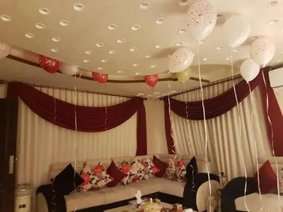 a living room with balloons hanging from a ceiling at 360 INNn in Irbid