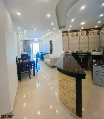 a large kitchen and living room with a counter top at La bedouin in Amman