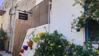 a sign on the side of a building with plants at Al Karak House sharing Apt in Kerak