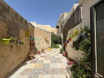 an alley with potted plants on the side of a building at Al Karak House sharing Apt in Kerak