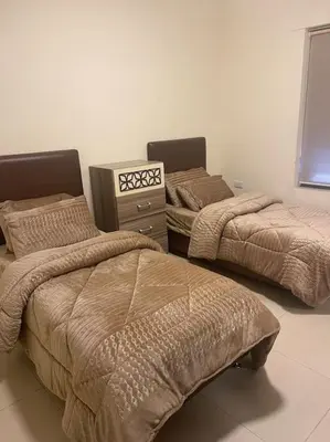 a room with two beds and a dresser at Sunset Balcony Retreat - Spacious and Comfortable 2 Bedrooms 2 Bathrooms in Amman