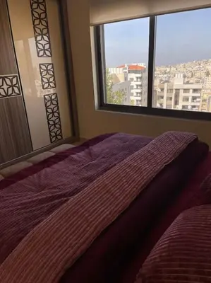 a bedroom with a purple bed and a window at Sunset Balcony Retreat - Spacious and Comfortable 2 Bedrooms 2 Bathrooms in Amman