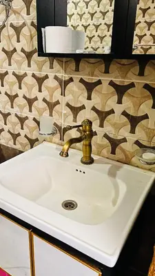 a white sink with a gold faucet in a bathroom at Wadi Rum Luxure desert Camp in Wadi Rum