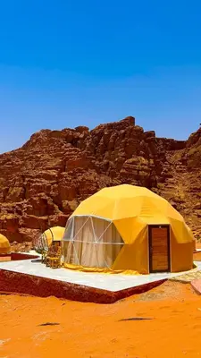 a yellow tent in the middle of a desert at Wadi Rum Luxure desert Camp in Wadi Rum