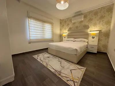 a bedroom with a bed and a window and a rug at COZY apt For long &short Stay in Amman