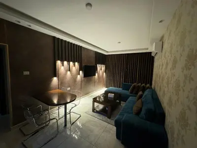 a living room with a blue couch and a table at COZY apt For long &short Stay in Amman