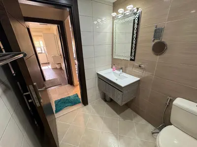 a bathroom with a sink and a toilet and a mirror at COZY apt For long &short Stay in Amman