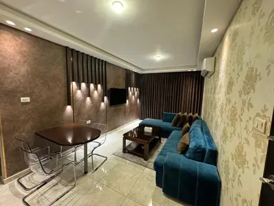 a living room with a blue couch and a table at COZY apt For long &short Stay in Amman