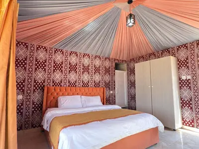 a bedroom with an orange bed in a tent at Fadi camp in Wadi Rum