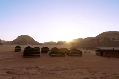 a group of tents in the desert at sunset at Fadi camp in Wadi Rum