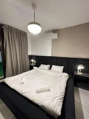 a bedroom with a large bed with white sheets at Stylish Luxe Apartment F-R 0003 in Amman